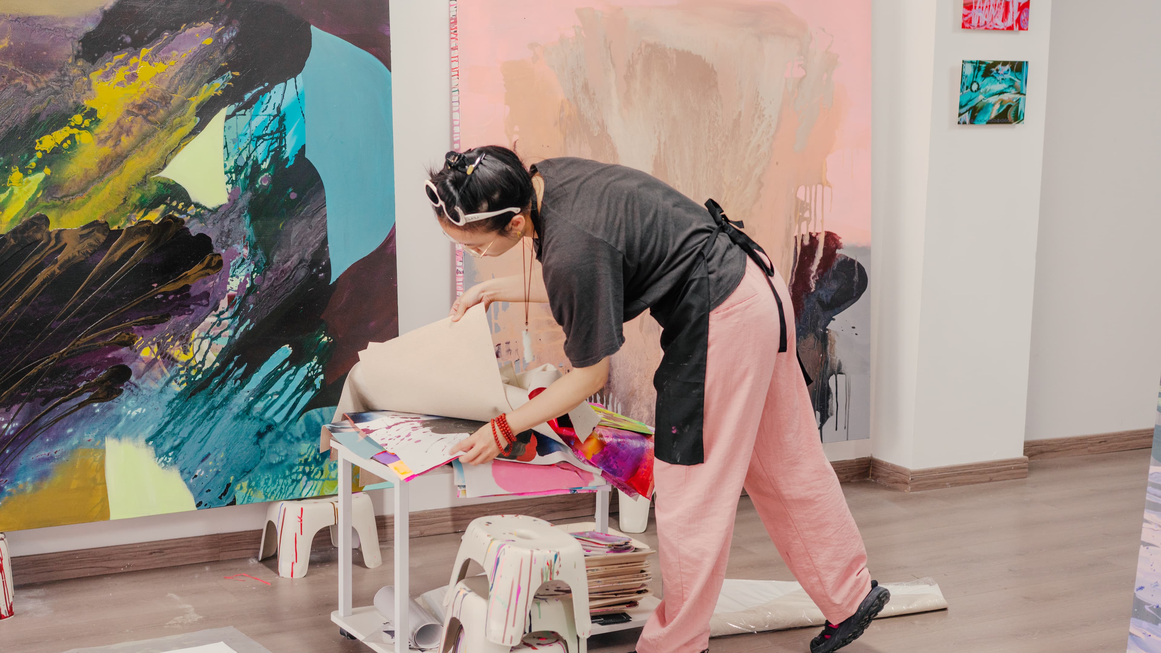 A person sorting printed artworks in Xuecan Ye's studio
